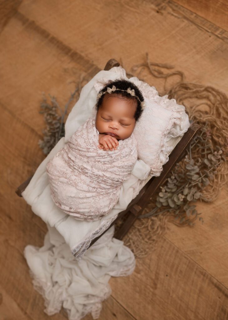 Professional newborn photographer in Winnipeg capturing a wrapped newborn portrait
